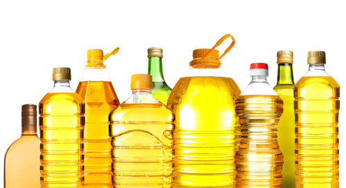 Different bottles with cooking oil on white background